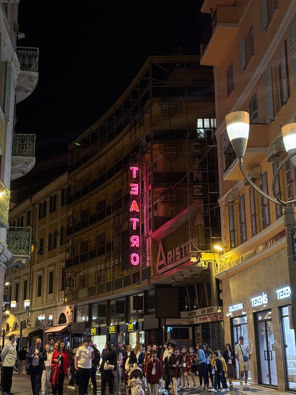 Crowd gathers near Cinema Ariston in Sanremo evening scene