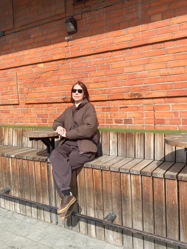 Woman rests on wooden benches in Yekaterinburg pedestrian area