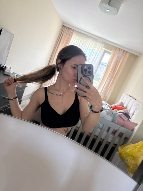 Woman takes mirror selfie, baby rests in Sofia home