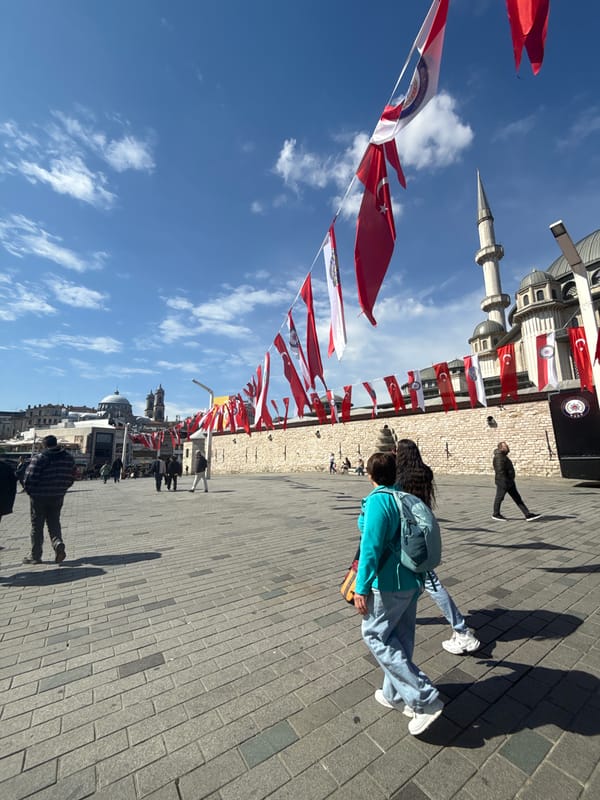 Turkish flags displayed on Beyoğlu street with minaret backdrop