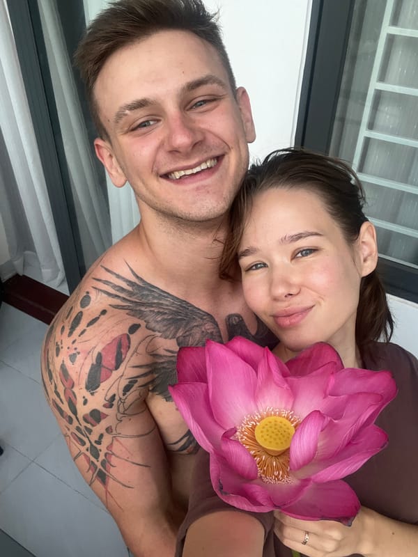 Couple poses with pink lotus flower in Vietnam heritage area