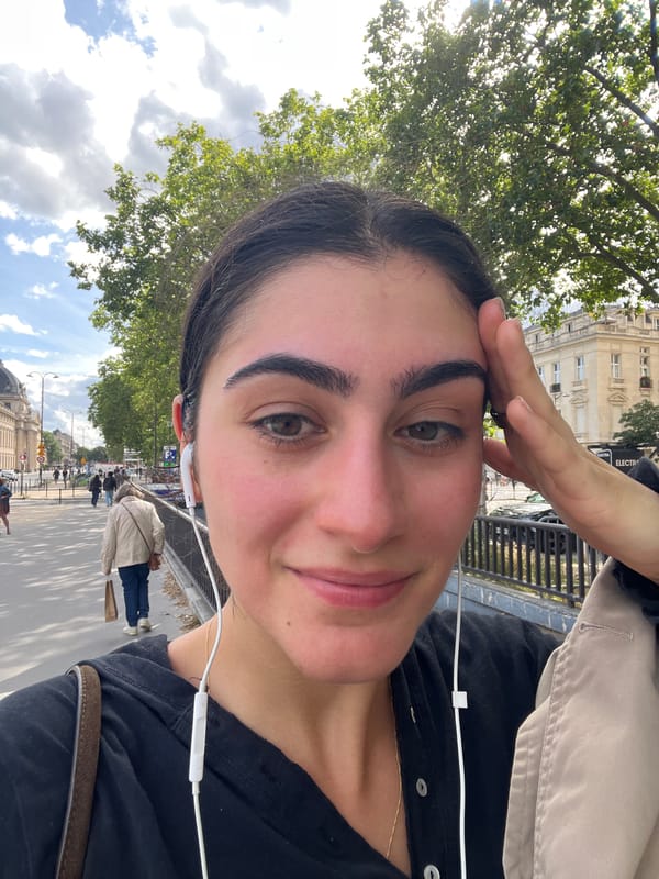 Woman takes selfies on Paris sidewalk