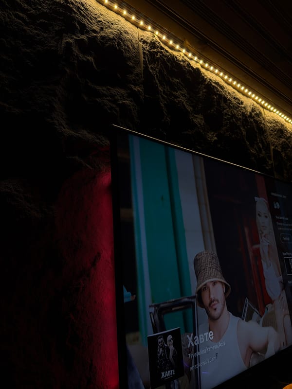 Indoor evening scene features lit wall and active fireplace