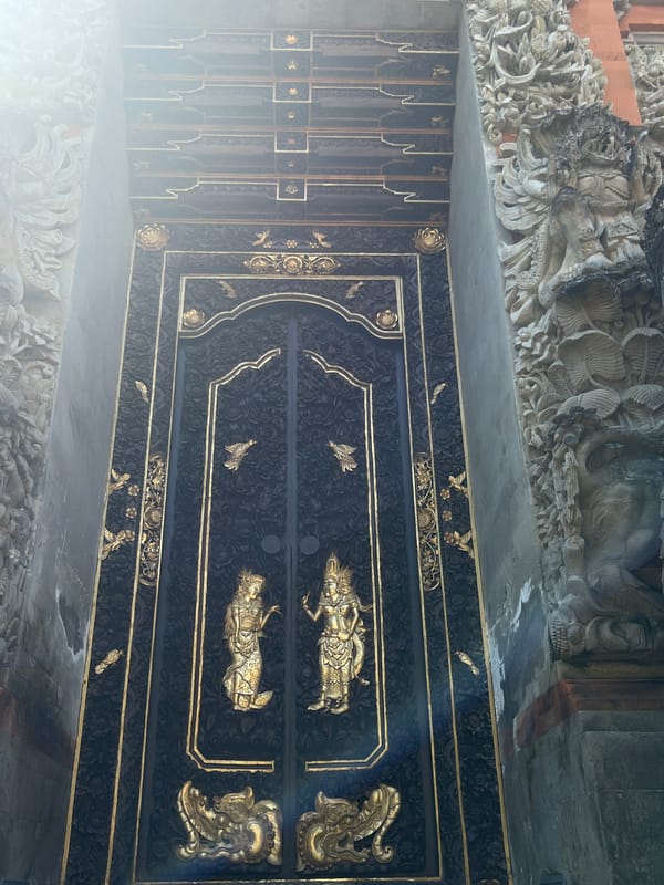 Tourist documents ornate Balinese temple architecture in Ubud