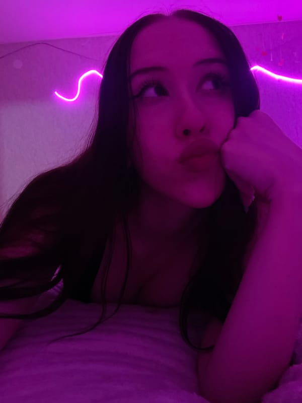 Bedroom self-portrait session under pink and purple neon lights
