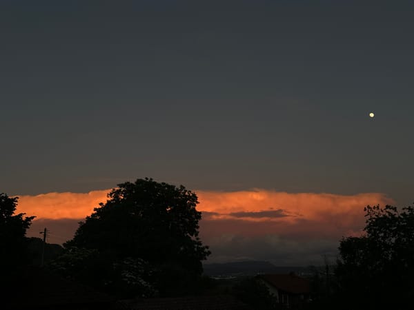 Orange cloud band illuminates evening sky over Kormiansko, Bulgaria