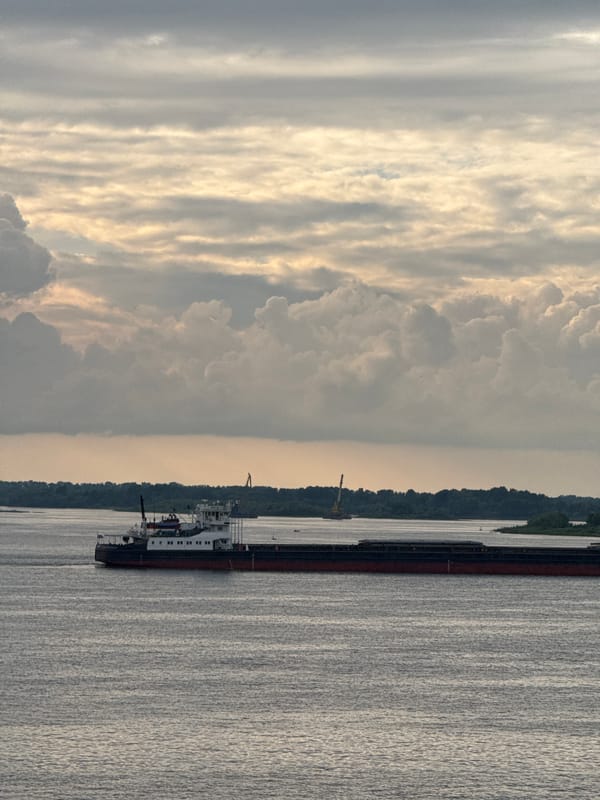 Cargo barge on the Volga under a layered sunset sky