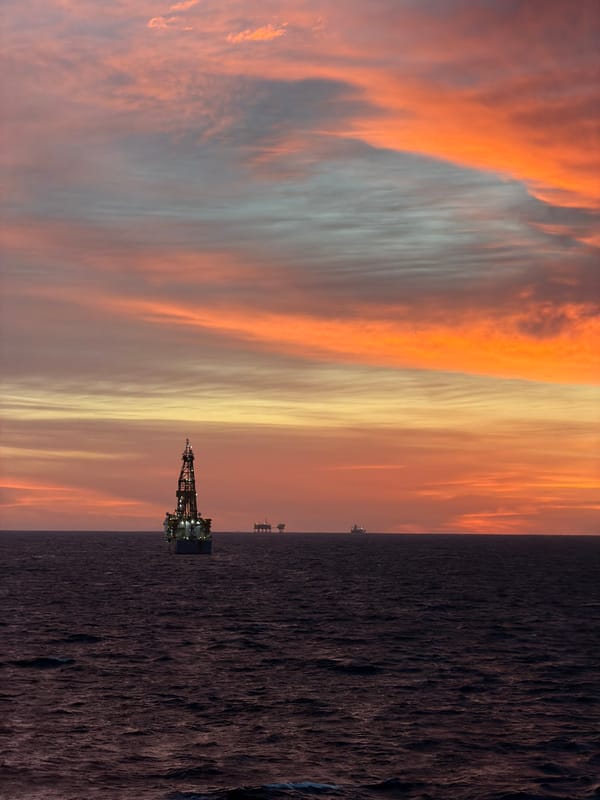 Offshore oil rig observed during dramatic sunrise over ocean