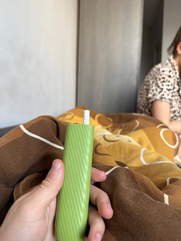 Person uses e-cigarette on blanket with child present