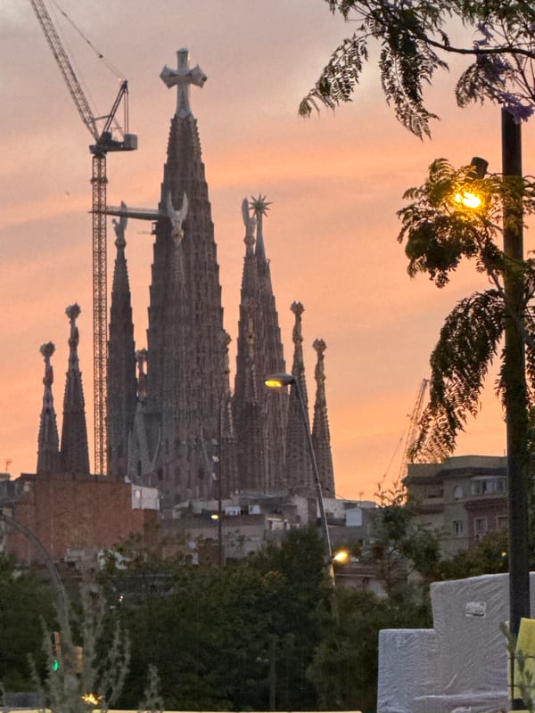 Barcelona evening stroll captures illuminated Torre Glòries at twilight