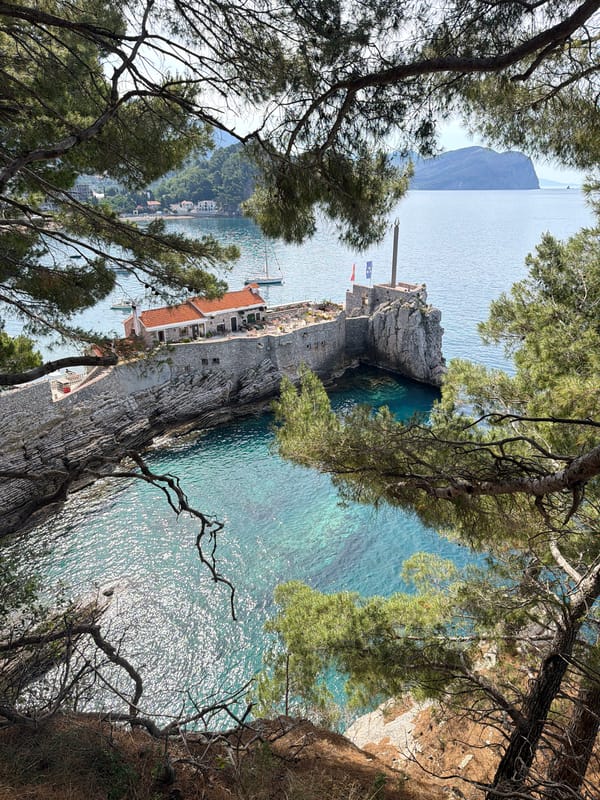 Woman drinks coffee at clifftop overlooking Adriatic in Montenegro