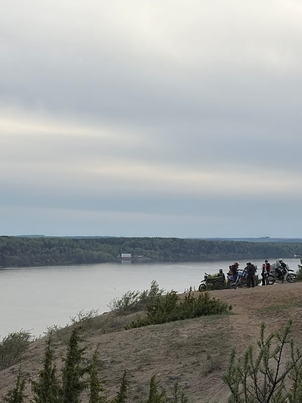Motorcycle group rides hills near river in Ольховка, Russia