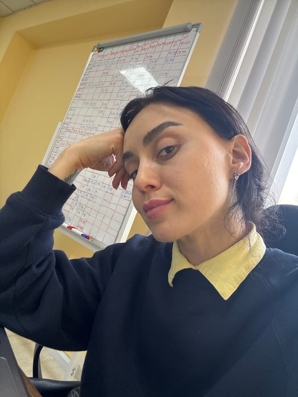 Woman in yellow shirt photographed indoors in Tbilisi