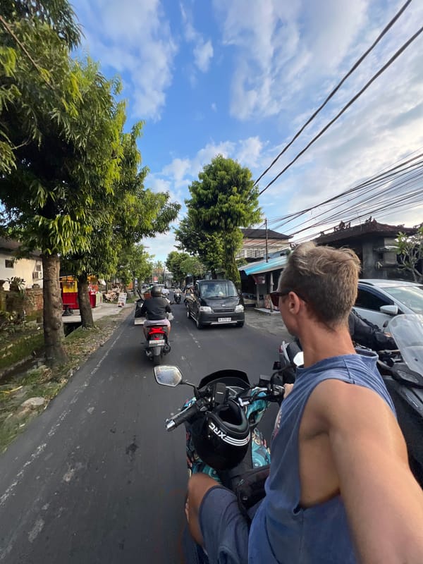 Motorcyclist navigates typical urban traffic in Sayan, Indonesia