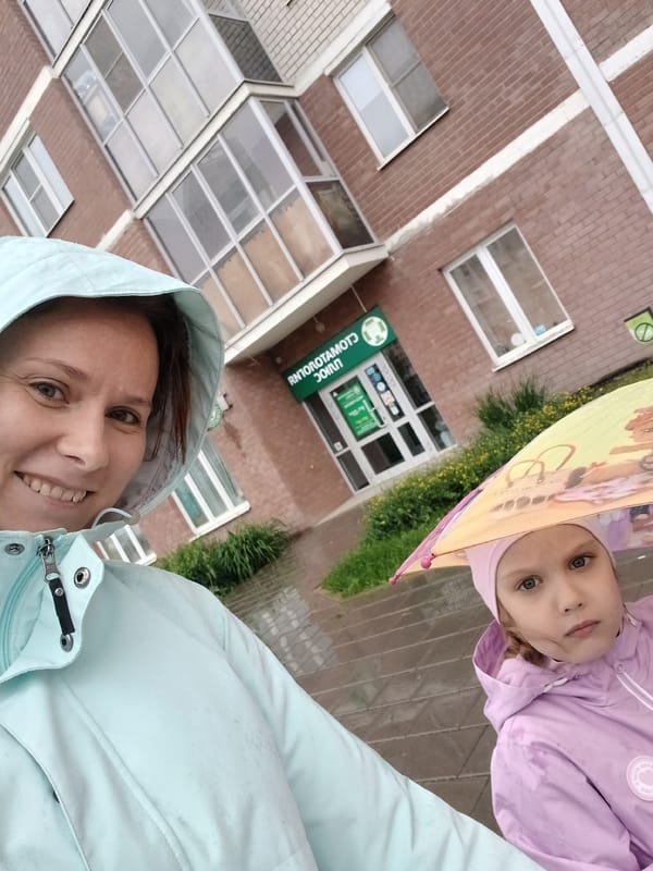 Woman takes selfie with girl during rainy day in Yekaterinburg