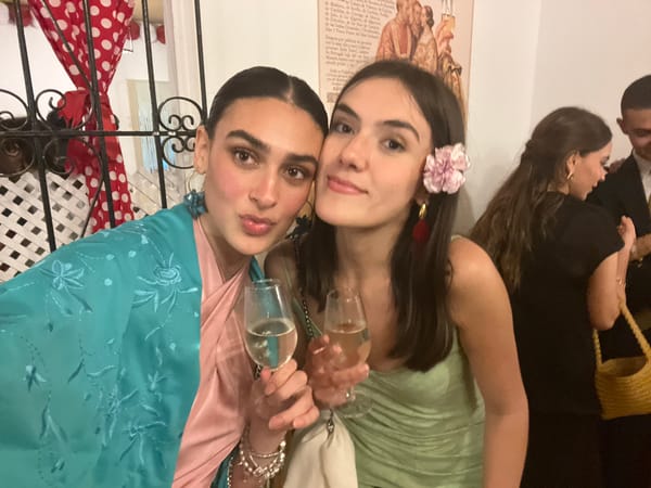 Two women toast with sherry in late-night Sevilla celebration