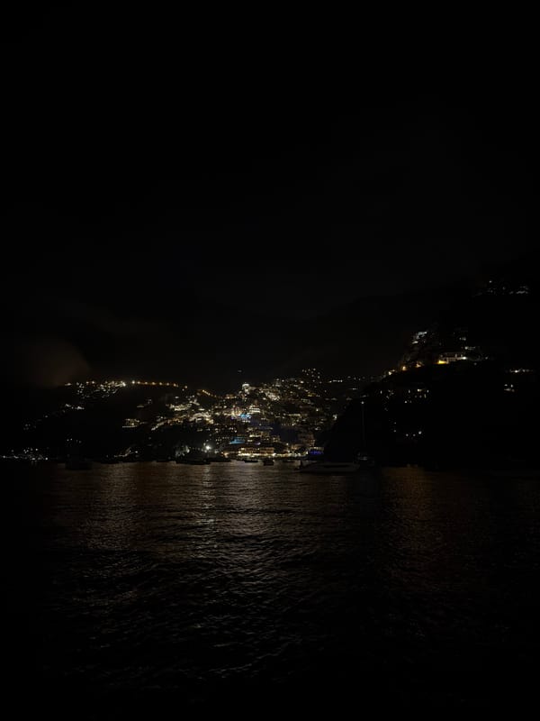 Nighttime views captured of illuminated Arienzo, Italy from water