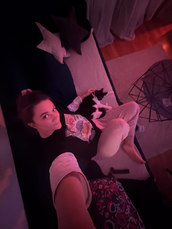 Woman relaxes with sleeping cat on Belgrade sofa