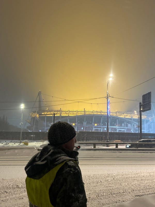 Snowy evening scene near Moscow stadium with waiting pedestrians