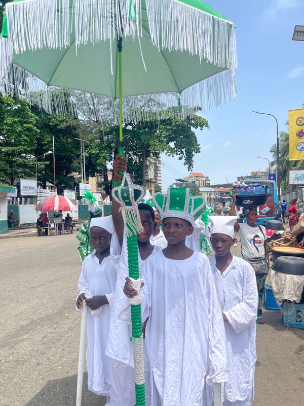 Children in ceremonial dress parade through Lagos streets