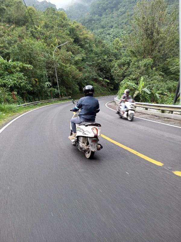 Motorcyclists navigate foggy mountain roads in Ariyalai, Sri Lanka
