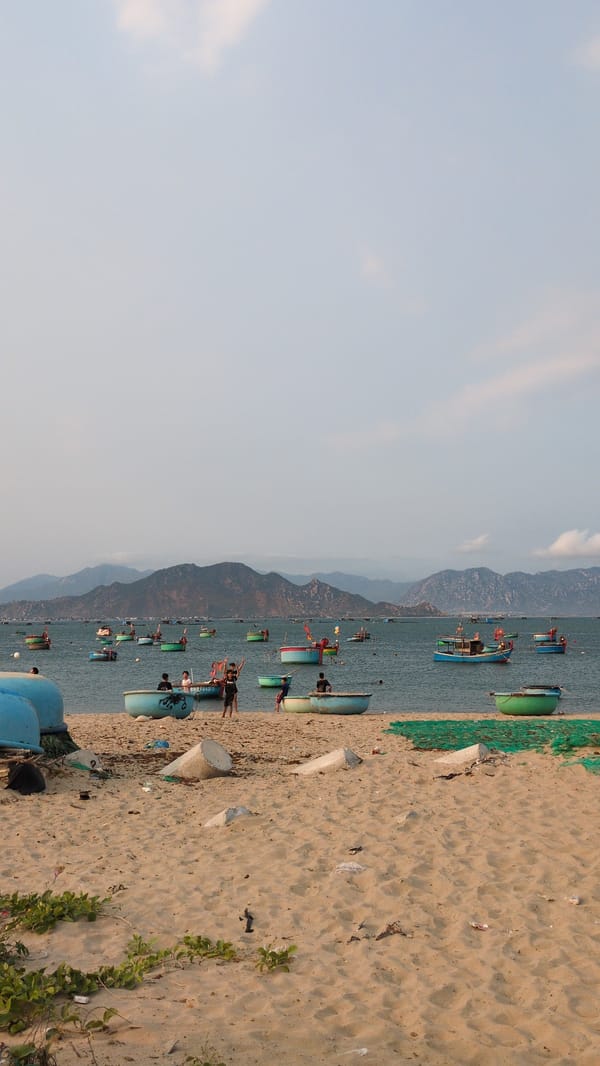 Children play among fishing boats on Vietnamese beach