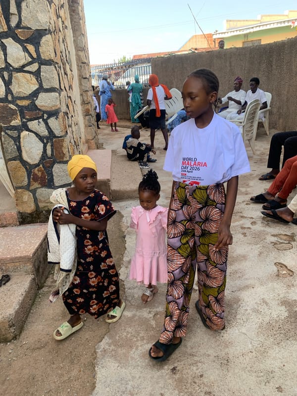 Community gathering at stone building in Jos, Nigeria