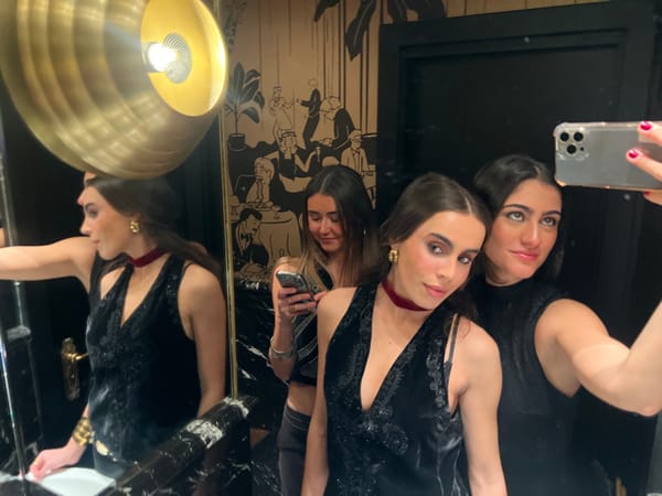 Three women take mirror selfies in Paris bathroom
