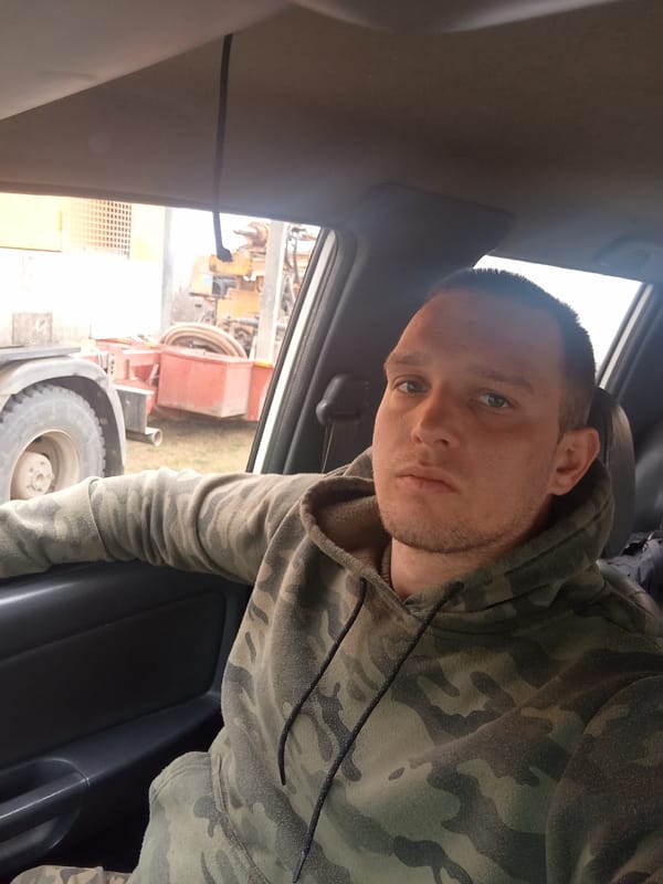 Man in camouflage hoodie sits near heavy machinery Bulgaria