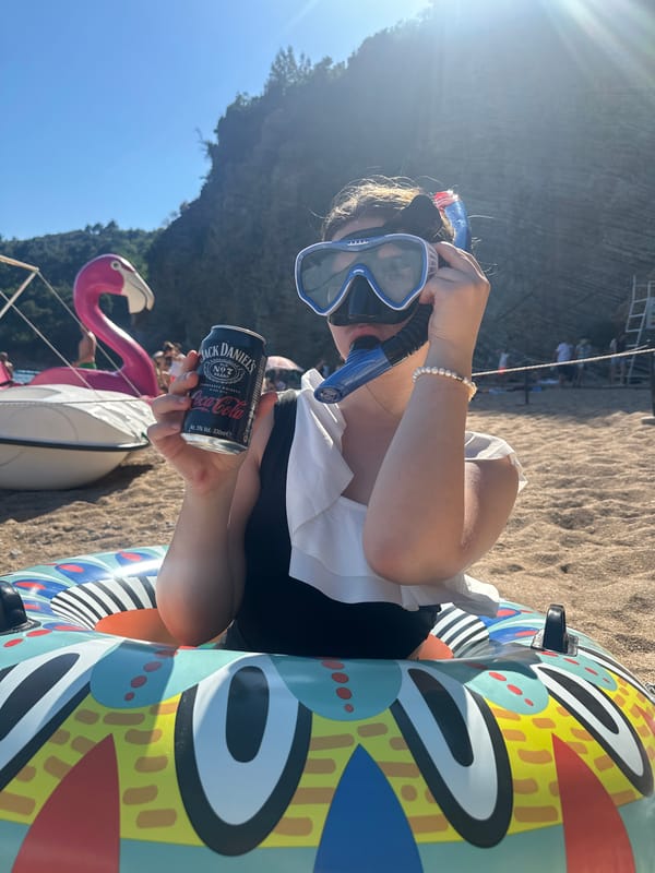 Woman enjoys beach day with drinks in Budva