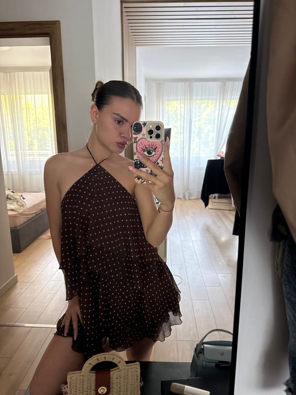 Woman takes mirror selfie in polka-dot dress