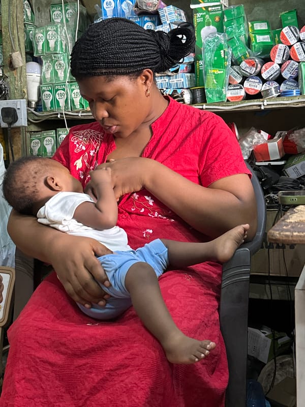 Quiet morning in a Narayi shop, baby in arms, bike outside
