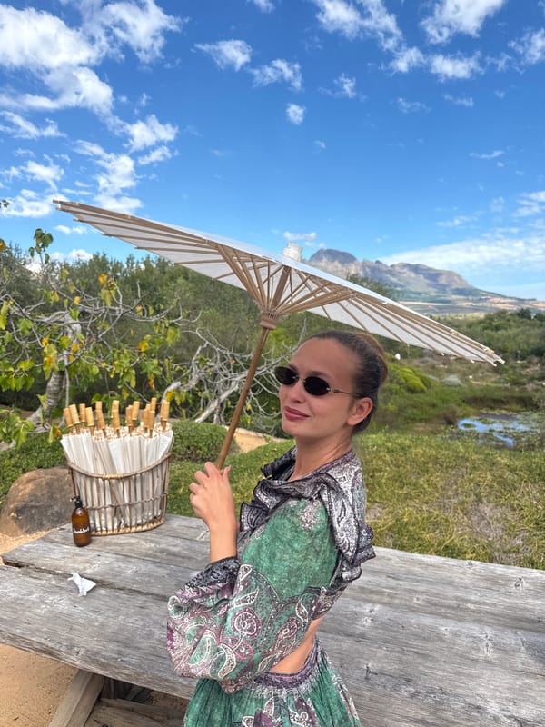 Woman with parasols visits sculptured gardens in Stellenbosch