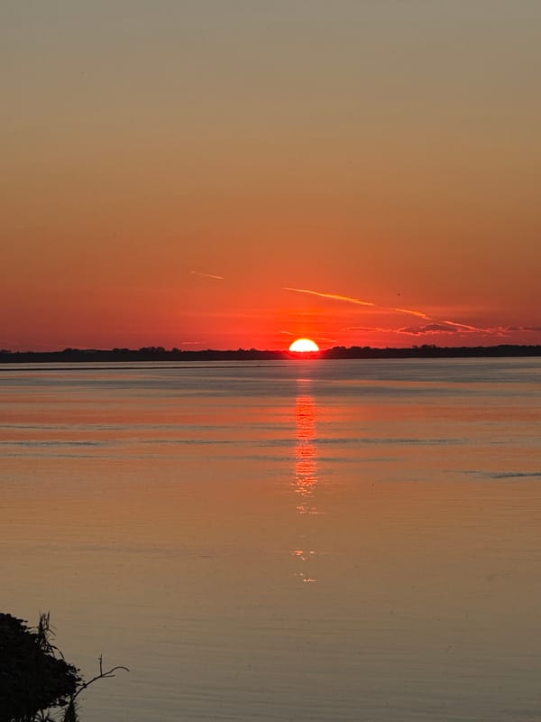 Sunset, moonrise, and red wine by the water in rural Russia