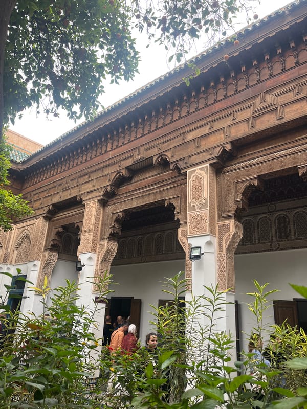 Visitors document ornate Moroccan palace architecture in Marrakesh
