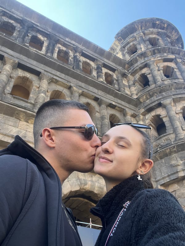 Couple visits historic Porta Nigra gate in Trier, Germany