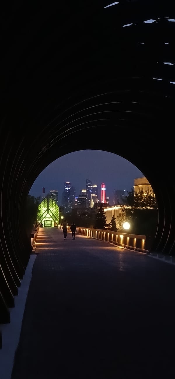 Street musician performs keyboard in underground walkway amid cityscape