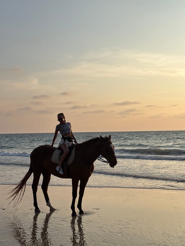 Woman enjoys sunset horseback ride on Thai beach