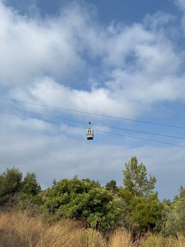 Cable cars glide above Alanya's coastal hillside on a summer morning.