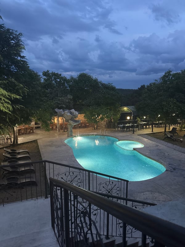 Poolside dusk at a Sredets resort, black cat on the steps