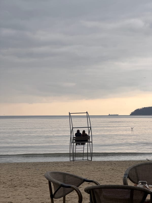 Couple sits in beach structure overlooking water in Varna
