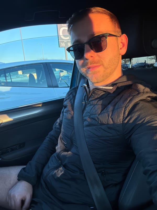 Man sits in parked car at London parking lot