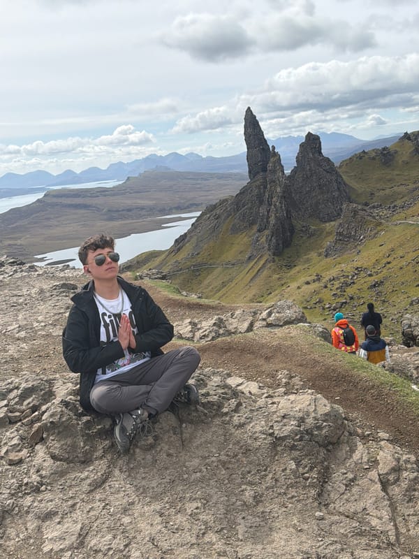 Hiker rests on rocky outcrop near Portree