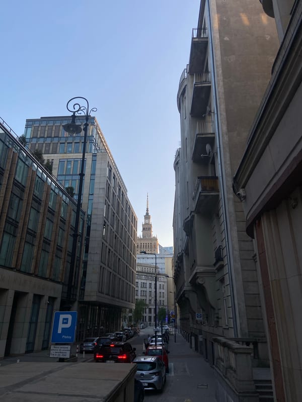 Central Warsaw streetscape, anchored by a café window view