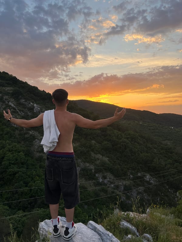 Hiker enjoys sunset views from rocky outcrop near Asenovgrad