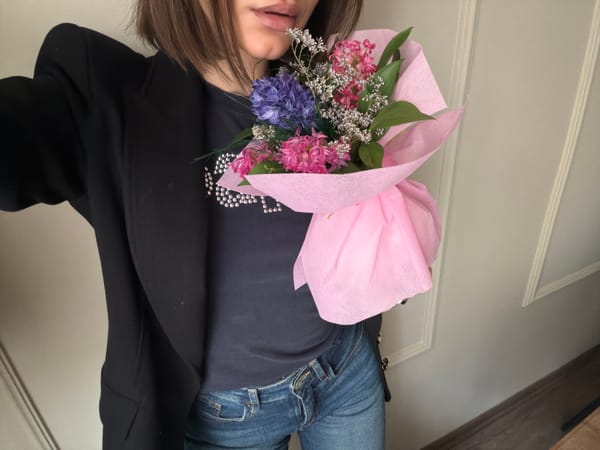 Person holds colorful flower bouquet indoors in Sofia