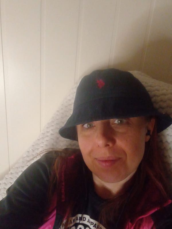 Woman in bucket hat photographed indoors, carpet view captured