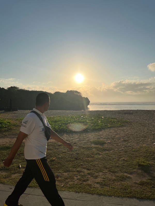 Sunrise activity along a Kuta Selatan beach with vendor cart