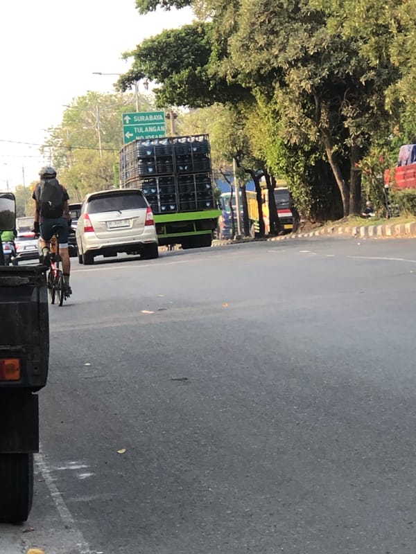 Mixed traffic moving through Kludan streets on a hazy morning