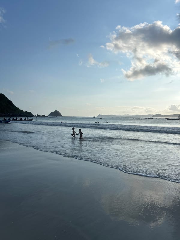 Quiet morning on Selongbelanak beach, figure wading into calm surf